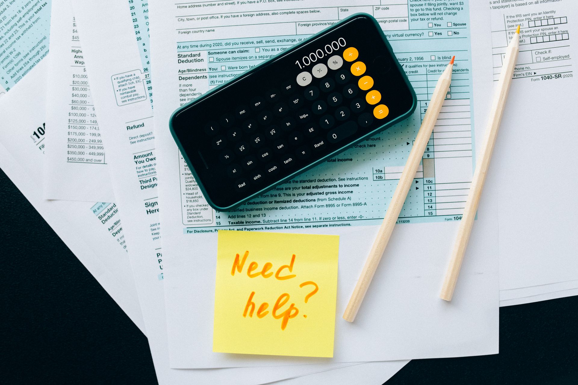 Tax forms, a calculator and pencils on a desk